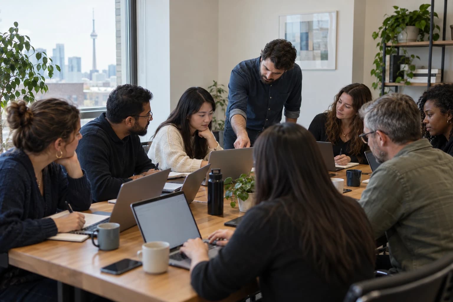 An instructor helping a participant during a hands-on team workshop in a Toronto office